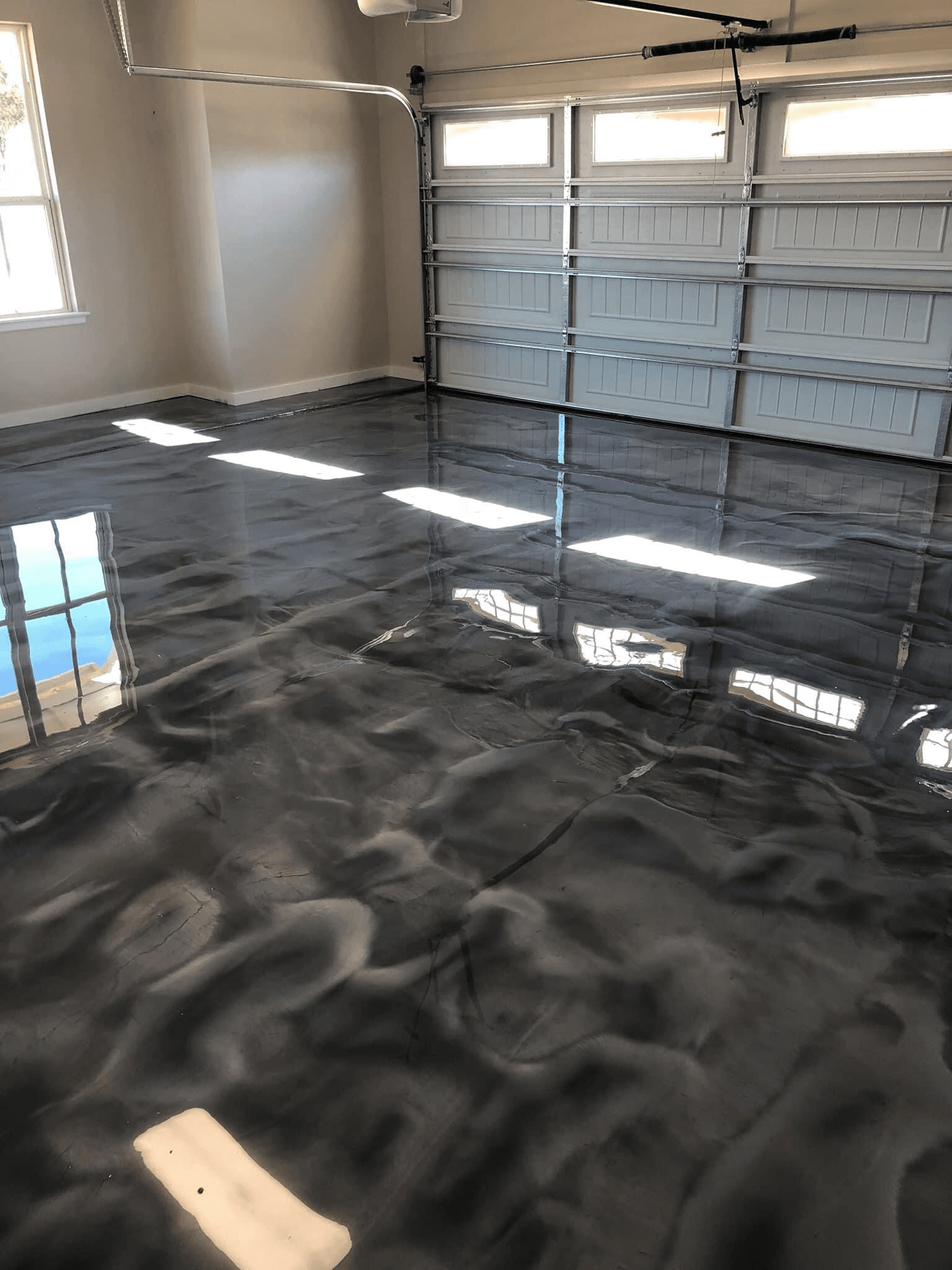 High-gloss metallic silver polymer floor coating finished in a two-car garage in Waterloo, Ontario